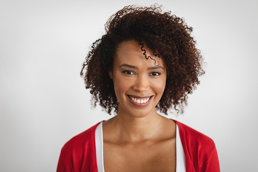 Portrait of african american woman smiling against grey background. hygiene and precautions for infection prevention during coronavirus covid 19 pandemic.