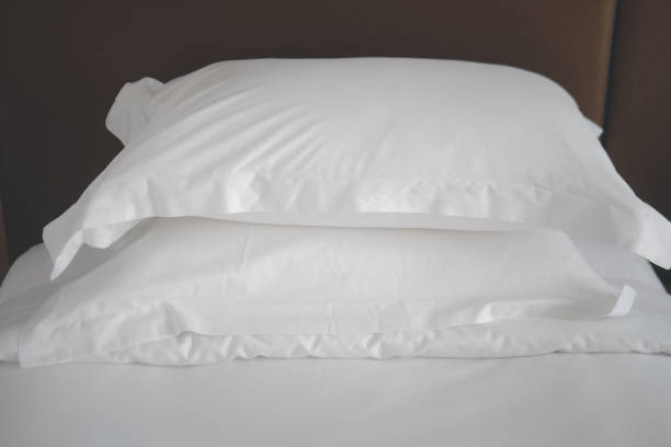 istock Close of white pillows on white bed sheets 1289202115