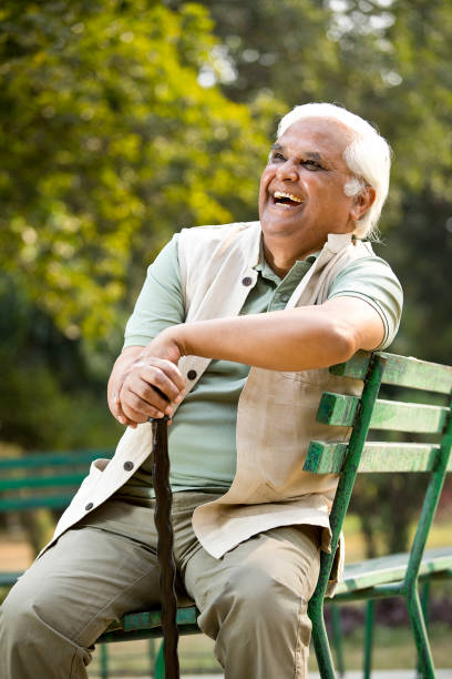 istock Happy senior man sitting at park 1289202661