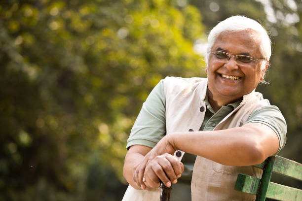 istock Happy senior man sitting at park 1289203233