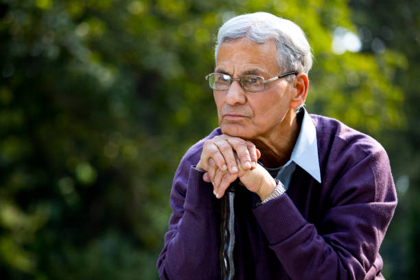 istock Thoughtful senior man sitting at park 1289203341