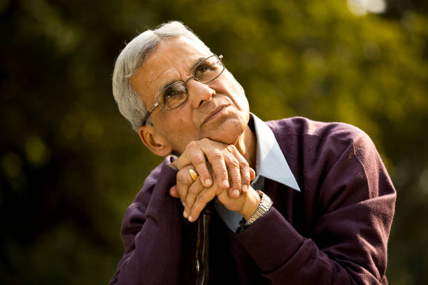istock Thoughtful senior man sitting at park 1289203429