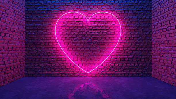 istock Glowing neon heart shaped like icon on brick wall in dark room 1289203536