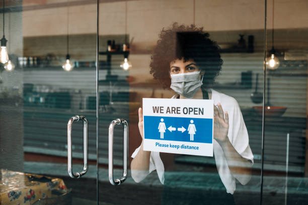 istock Restaurant female owner with face mask, reopens after Coronavirus lockdown. 1289203894