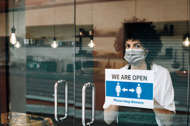 istock Restaurant female owner with face mask, reopens after Coronavirus lockdown. 1289203961