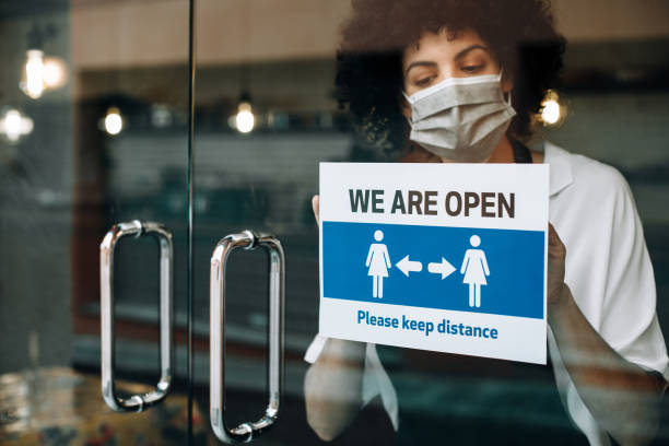 istock Restaurant female owner with protective face mask, reopens after lockdown quarantine. 1289203978