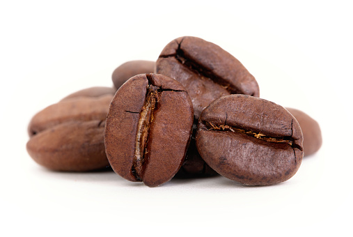 Close-up of roasted coffee beans on completely white background