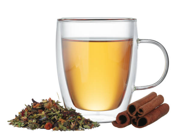 istock Glass cup of tea and cinnamon sticks isolated on white 1289205510