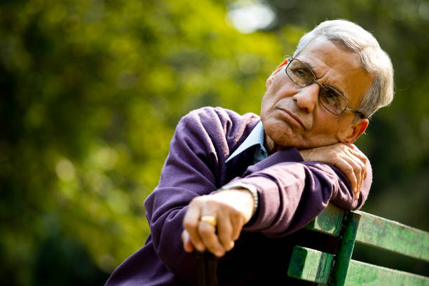 istock Thoughtful senior man sitting at park 1289206193