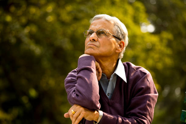 istock Thoughtful senior man sitting at park 1289206410