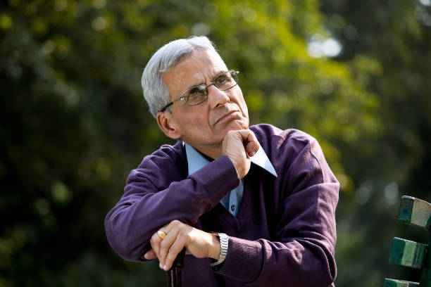 istock Thoughtful senior man sitting at park 1289206442