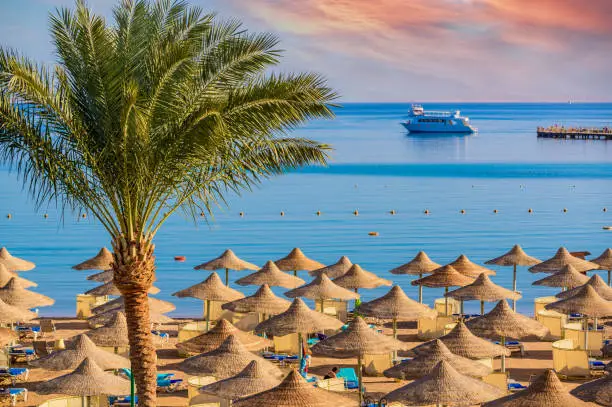 Relaxing at paradise beach - Chaise lounge and parasols - travel destination Hurghada, Egypt