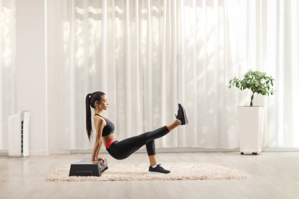 istock Woman doing exercises on a stepper at home 1289209159