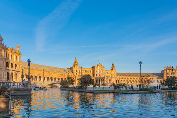 plaza de espana square au coucher du soleil avec bateaux sur le canal à belle séville, espagne - spain plaza de espana europe town square photos et images de collection