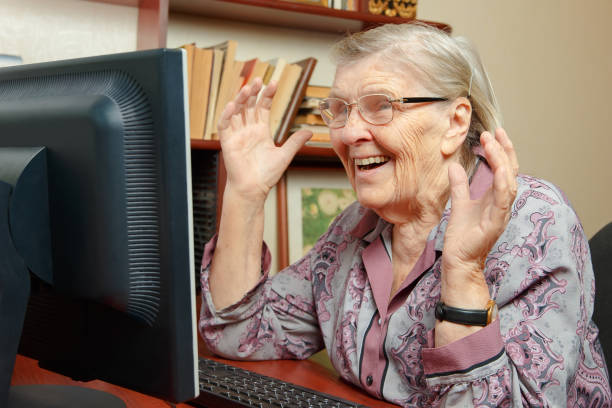 Elderly woman watching the news on the internet stock photo