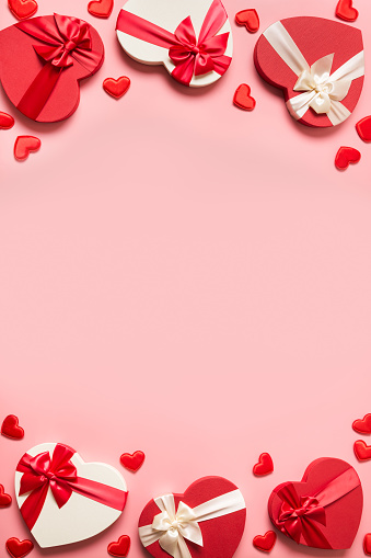 Beautiful bouquet of red roses in big pink hat box in heart shape on table indoors, copy space. Wedding concept, Valentines Day