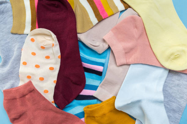 istock Many multicolored new socks stacked against a blue background. top view. place for text. 1289212902