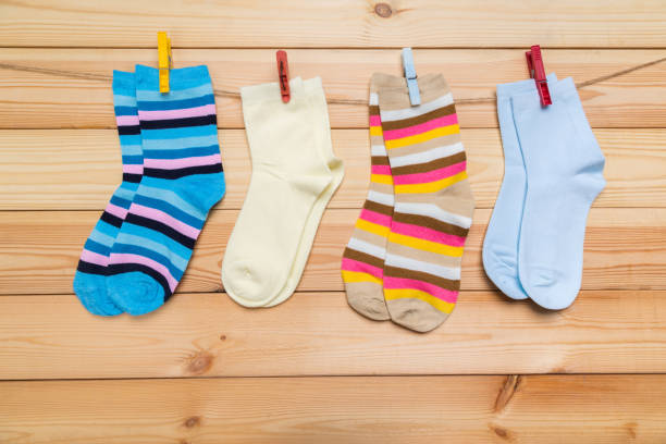 istock multicolored socks hanging on a clothesline with clothespins on a wooden background 1289212918