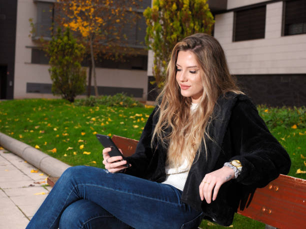 istock Young woman checking messages on her mobile phone 1289215358