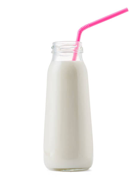 istock Glass cup of milk with a straw isolated on white 1289220731