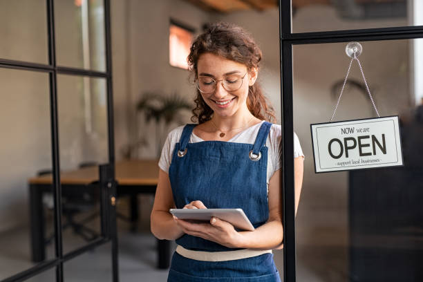 istock Small business owner using digital tablet at entrance 1289220876