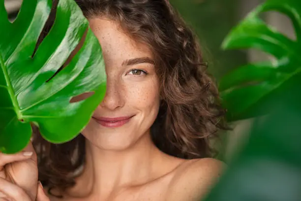 Photo of Beauty natural woman covering her face with tropical leaf