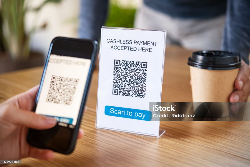 Qr code digital payment at coffee shop Customer scanning tag in coffee shop to pay online. Close up of woman hand holding smartphone and scanning qr code for cashless payment at cafeteria. Girl  framing qr code in coffee shop to make a purchase, small business accepts digital payment. QR Code Stock Photo