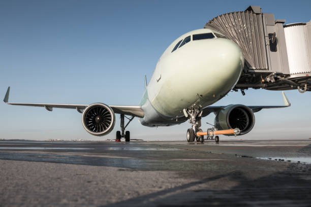 istock Passenger jet plane with towbar at the boarding bridge 1289222090