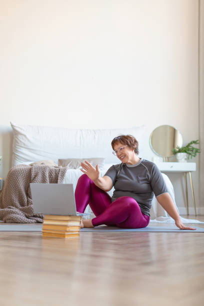 istock Senior woman having video conversation with a trainer online before a Pilates workout 1289222285