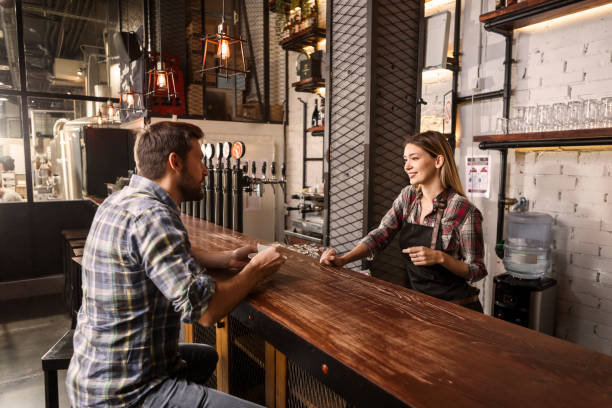 istock Smiling Female Bartender serving coffee to a customer 1289222305