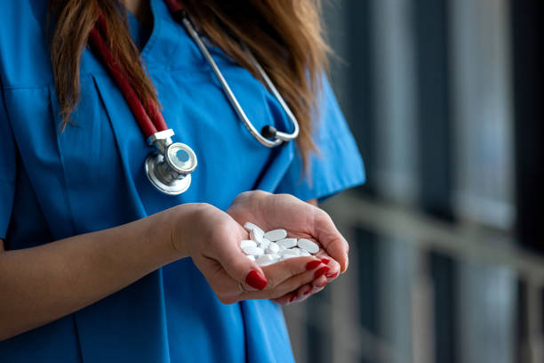 istock doctor in blue uniform holding many white pills in his hands 1289224231