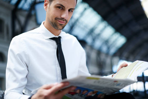 istock Confident man with newspaper looking at camera 1289226534