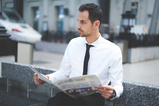 istock Pensive businessman reading newspaper during break 1289226554