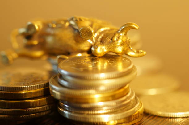 istock Metal bull with coins on the table. 1289227890
