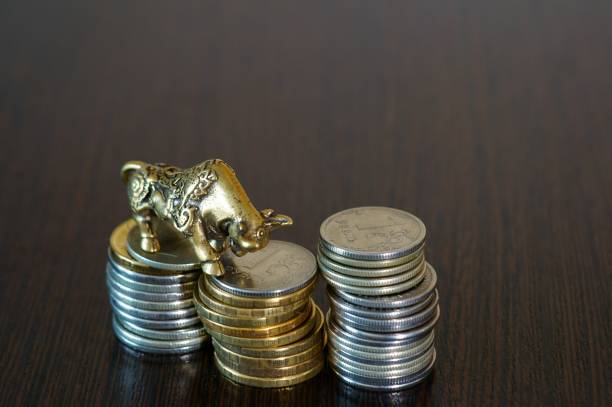 istock Metal bull with coins on the table. 1289227930