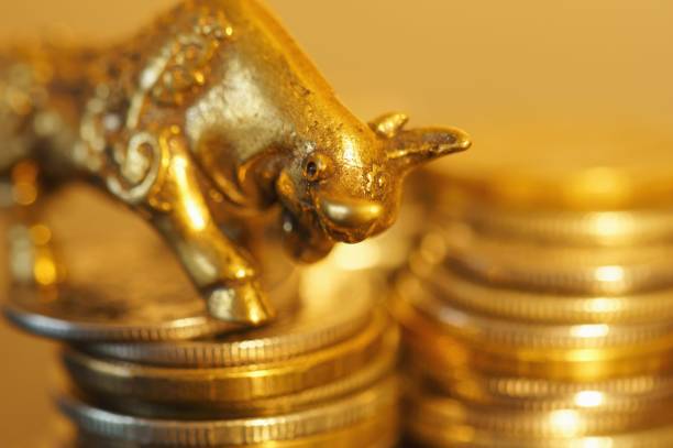 istock Metal bull with coins on the table. 1289227973