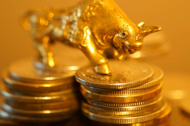 istock Metal bull with coins on the table. 1289228024