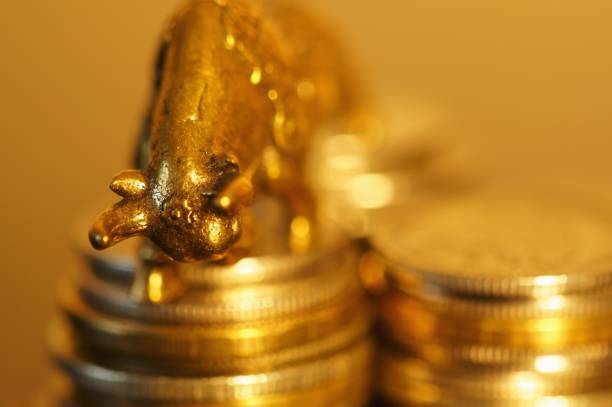 istock Metal bull with coins on the table. 1289228247