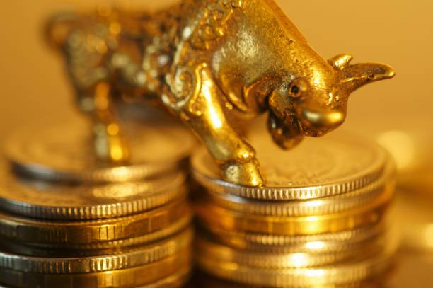 istock Metal bull with coins on the table. 1289228262