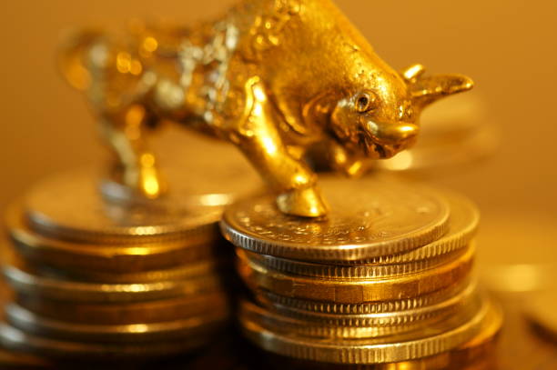 istock Metal bull with coins on the table. 1289228299
