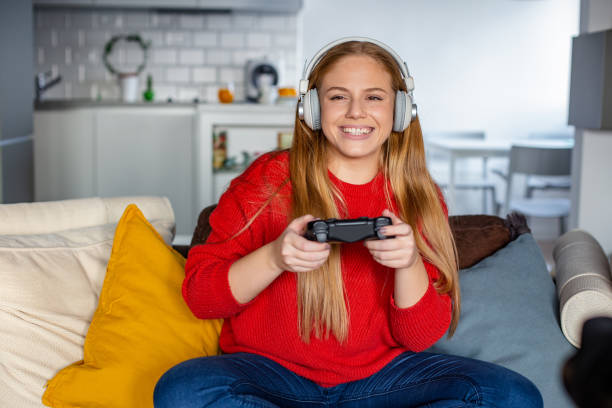 istock Young woman is playing video games at home 1289234599