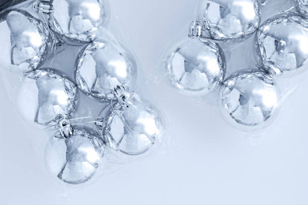 istock Christmas silver balls in two transparent packaging on white background. 1289235450