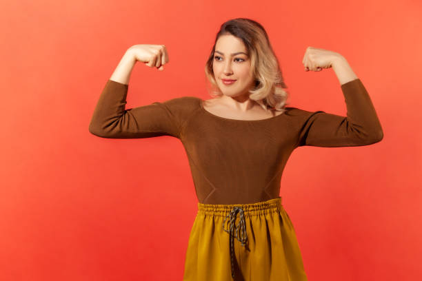 istock Strong woman showing her arm muscles 1289236140