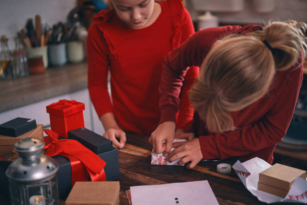 istock Little Girls Having Fun with Wrapping Christmas Presents 1289239375