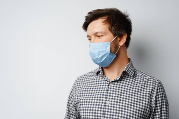istock Man wearing hygienic mask against grey background 1289241318