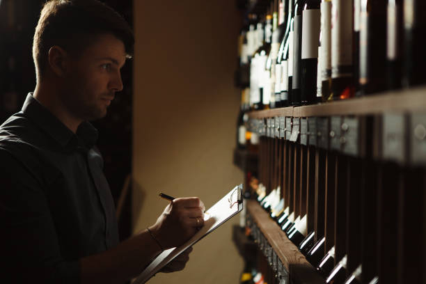 istock Sommelier writes at notes, putting down information on wine products in cellar 1289241507
