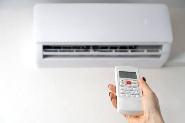 istock Room air conditioning. Air conditioner remote control in female hands. Copy space. 1289242446