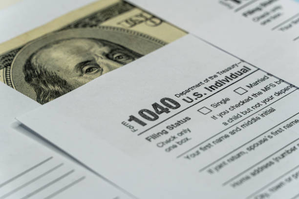 istock Tax form with pen and dollar banknote 1289245699