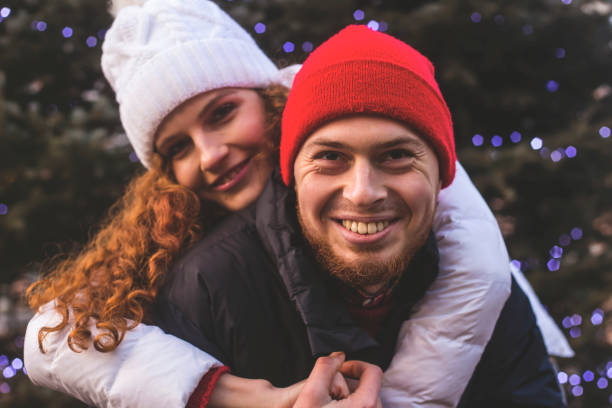 istock Loving boyfriend and girlfriend are hugging by Christmas tree 1289249967