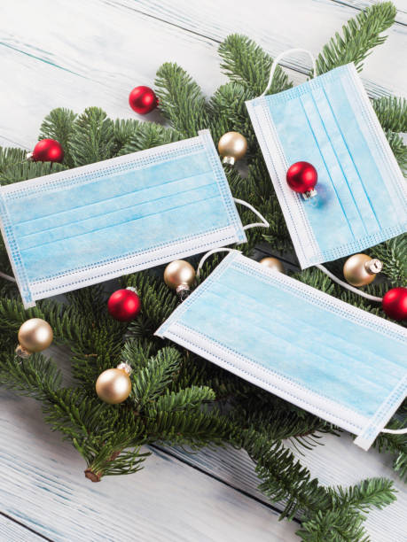 istock Mini Christmas tree on wood table with face masks 1289250778